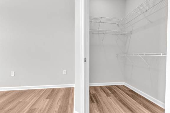 A room with a white door and a wooden floor.