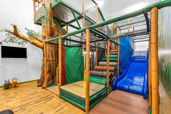 A play area with a slide and a treehouse.