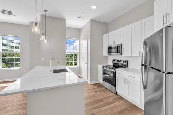 A modern kitchen with a large island and stainless steel appliances.