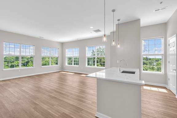 A kitchen with a large island and pendant lights.
