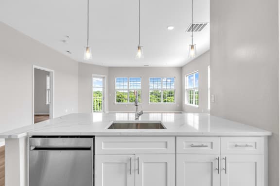 A modern kitchen with white cabinets and a large island.