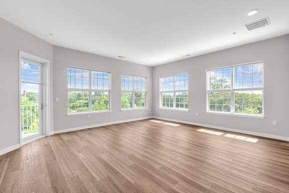 A room with wooden floors and large windows.