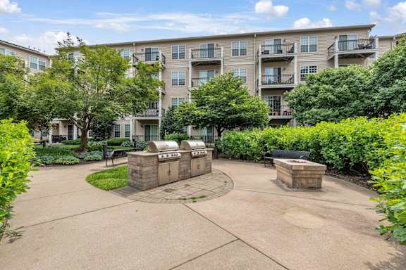 A courtyard with a bench and a wall in front of apartment buildings.