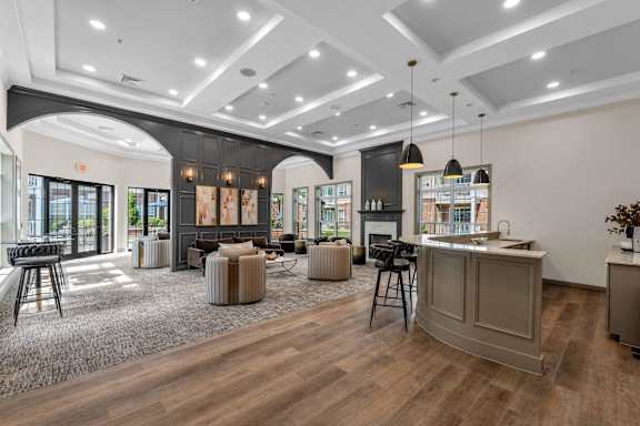 A spacious living room with a kitchen area in the background.