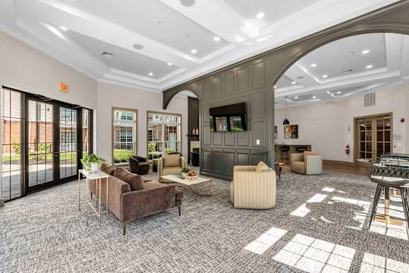 A living room with a grey carpet and furniture.