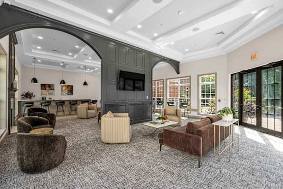 A living room with a grey carpet and furniture.