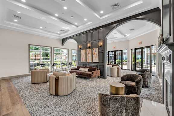 A large room with a carpeted floor and a variety of seating options.
