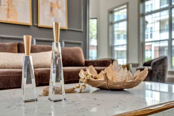 Two glass vases with wooden sticks in them sit on a table.