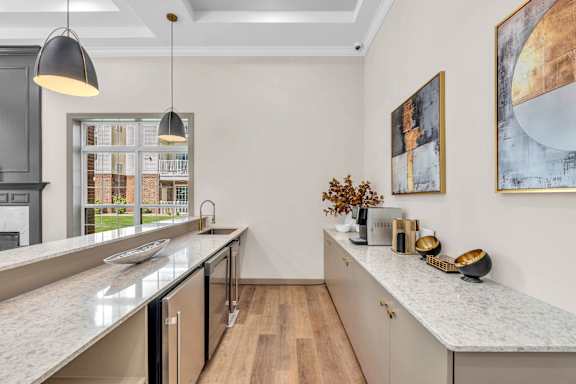 A kitchen with a marble countertop and wooden floors.