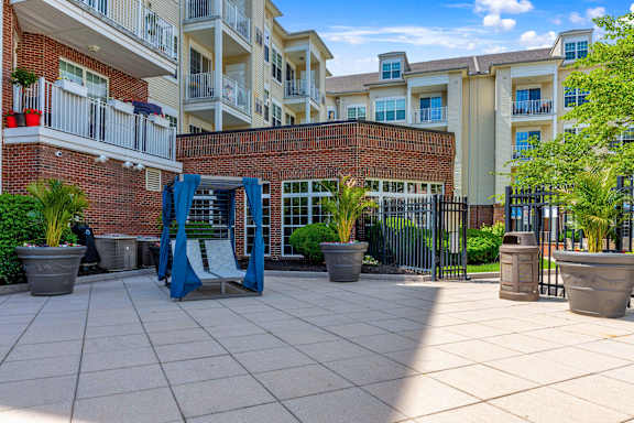 A playground area with a slide and potted plants in front of apartment buildings.