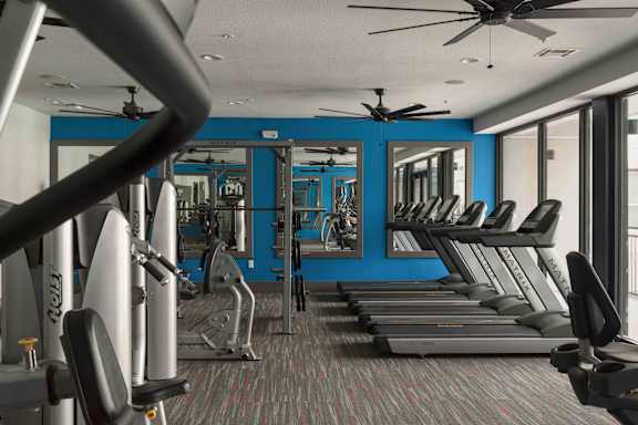 A gym with treadmills, weights, and a fan at Regatta Sloans Lake Apartments, Denver, CO
