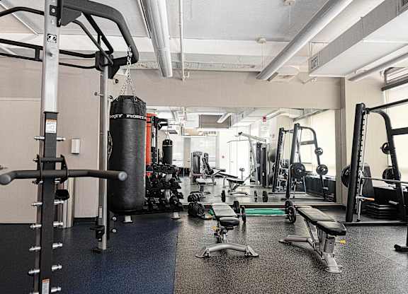 Fitness center with weight training equipment and punching bag at 222 Saratoga Apartments, Baltimore, Maryland