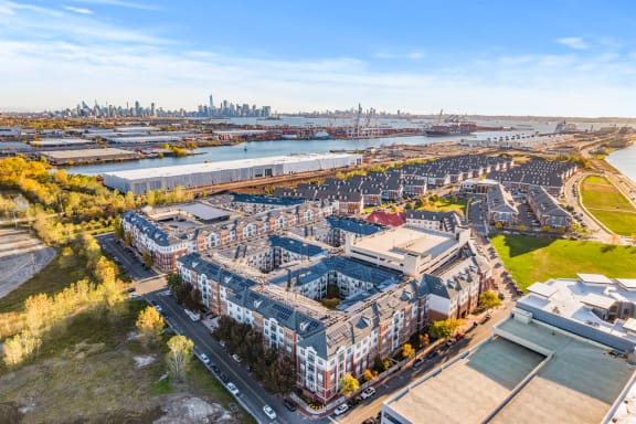 an aerial view of an apartment complex with a city in the background at Harbor Pointe, New Jersey, 07002