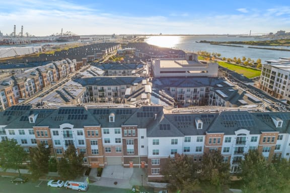 an aerial view of an apartment complex with a river in the background at Harbor Pointe, Bayonne, New Jersey