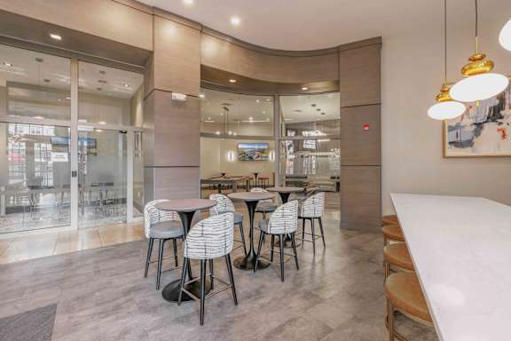 A clubhouse with a modern dining area with a glass wall and a curved ceiling at Harbor Pointe Apartments, New Jersey, 07002