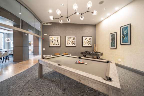 A pool table in a room with a grey carpet at Harbor Pointe Apartments, New Jersey