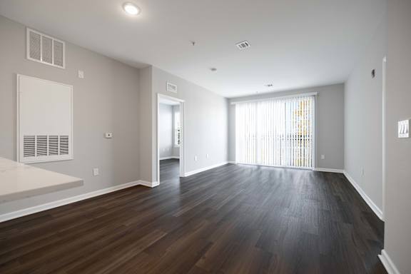 A large empty room with wooden floors and white walls.
