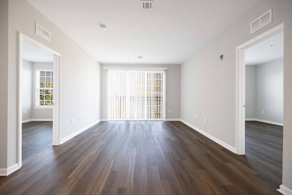 A large empty room with wooden floors and white walls.