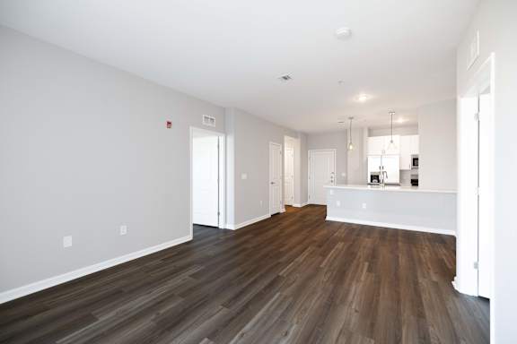 A room with wooden flooring and white walls.
