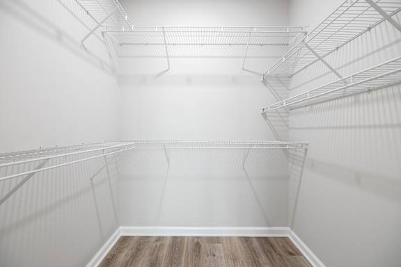 Empty white shelves in a room with wooden flooring.