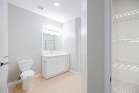 A white bathroom with a toilet, sink, and medicine cabinet.