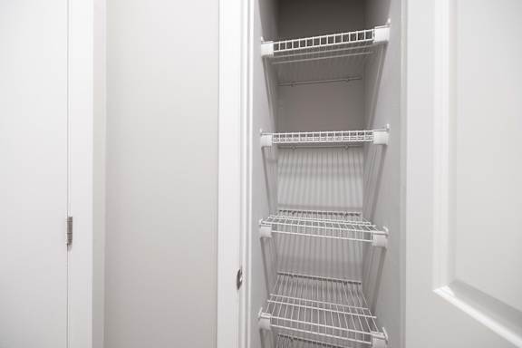 Empty white shelves in a white pantry.
