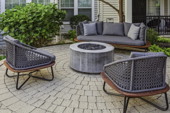 a stone patio with chairs and a fire pit at Metro 303, Hempstead, NY