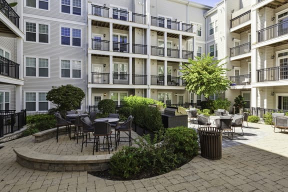 an outdoor courtyard with tables and chairs at an apartment building at Metro 303, Hempstead, NY 11550