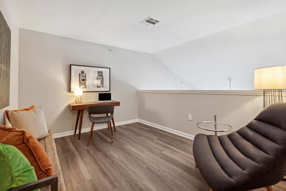 a living room with a couch and a chair and a desk at Metro 303, Hempstead, New York