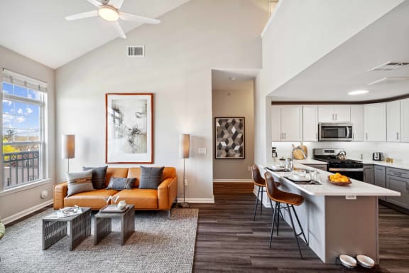 a living room with a couch and a kitchen with a table at Metro 303, Hempstead