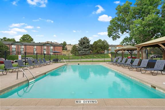 A pool with a NO DIVING sign in the foreground at Mountain Vista Apartments, Lakewood, CO