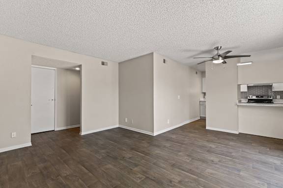 A room with a ceiling fan and wooden flooring.