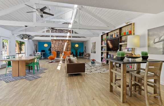 A living room with a wooden floor and a ceiling fan.