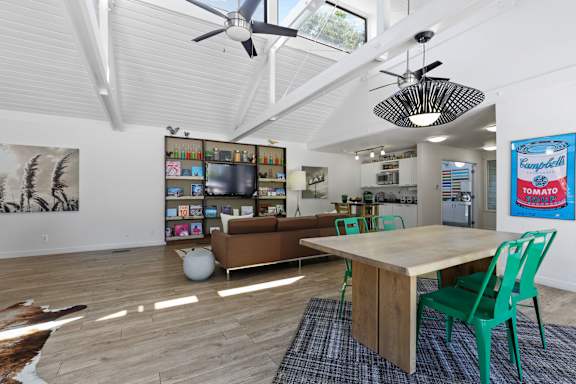 A room with a table, chairs and a ceiling fan.