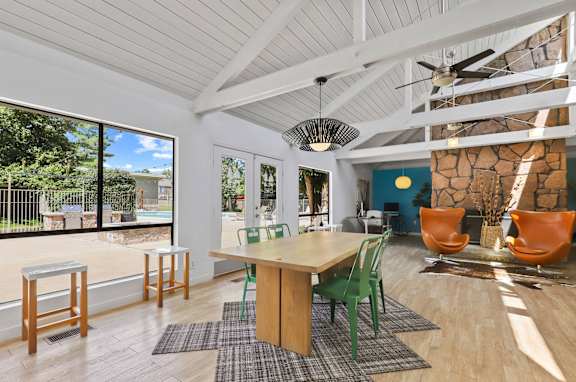 A room with a table and chairs and a ceiling fan.