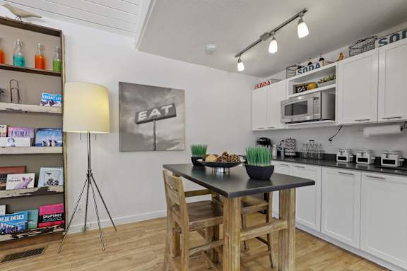 A kitchen with a table and chairs in the middle of it.