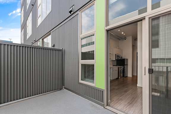 A modern house with a grey exterior and a glass door leading to the interior. at RiDE at RiNo Apartments, Denver, CO