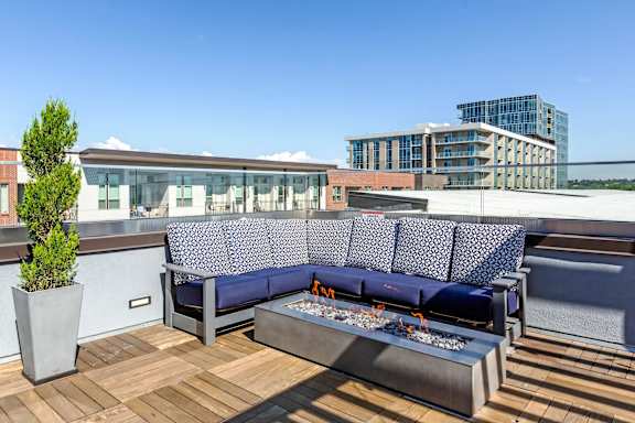 A blue couch with a white patterned cushion is on a wooden deck at Regatta Sloans Lake Apartments, Denver, CO, 80204