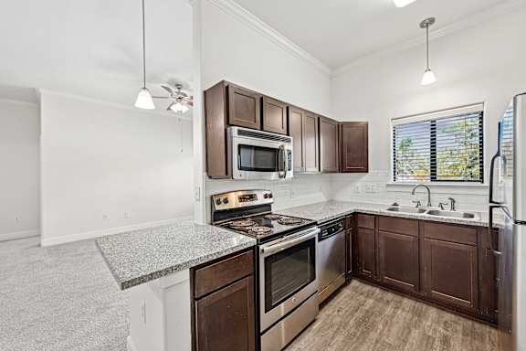 Dark wood cabinets in kitchen at The Laurel at Vintage Park 55+ Apartments, Texas, 77377