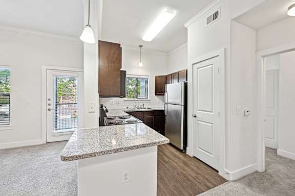 Kitchen with granite countertop and stainless steel appliances at The Laurel at Vintage Park 55+ Apartments, Tomball, TX, 77377