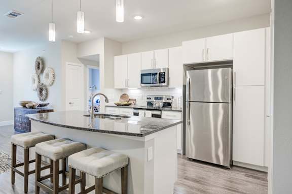 A modern kitchen with a large island and stainless steel appliances.