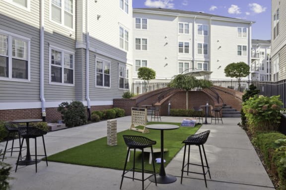 a patio with tables and chairs in front of a building at West 130, New York , 11552