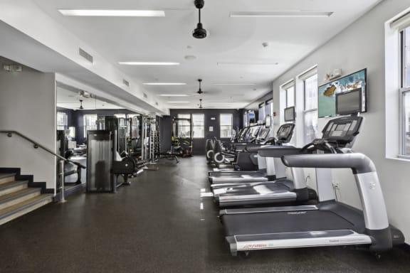 a gym with treadmills and other cardio equipment in a building at West 130, West Hempstead, New York