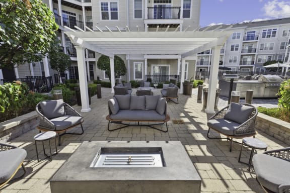 a patio with couches and chairs and a fire pit at West 130, West Hempstead, NY 11552