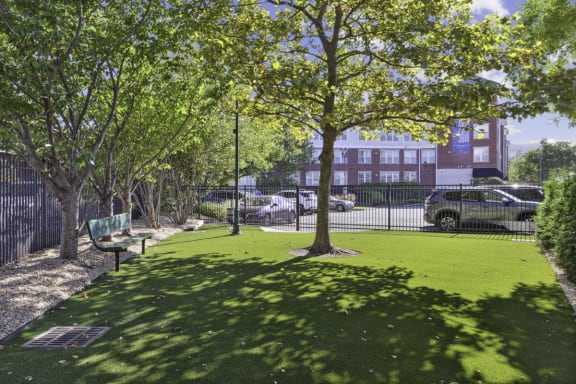 a park with green grass and trees and a fence at West 130, New York , 11552