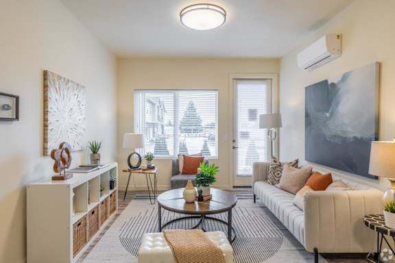 A living room with a white couch, a coffee table, and a large painting on the wall.