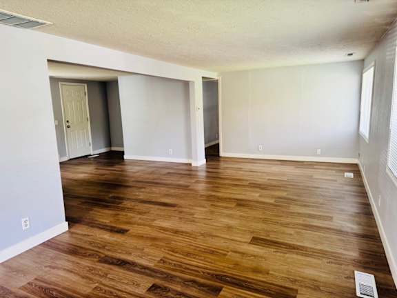 A room with wooden flooring and white walls.