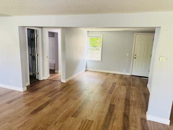 A room with wooden flooring and white walls.