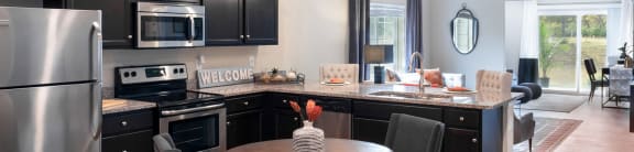 a kitchen with black cabinets and stainless steel appliances and a table