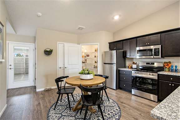 A kitchen with a table and chairs in the middle of the room.